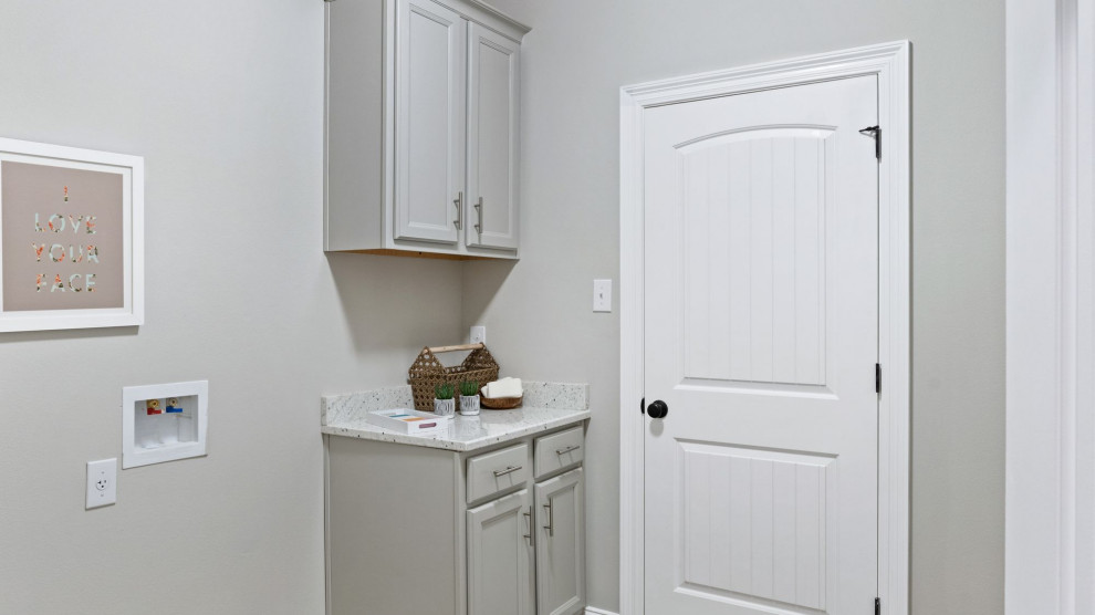 Inspiration for a mid-sized traditional single-wall dedicated laundry room in Other with grey cabinets, granite benchtops, beige walls, a side-by-side washer and dryer, brown floor and white benchtop.