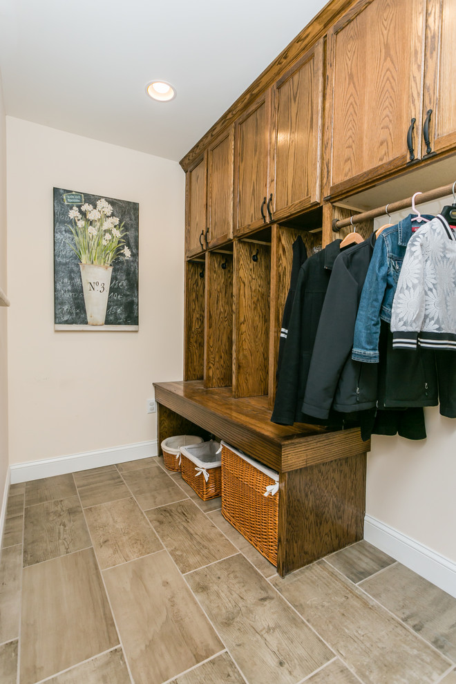 This is an example of a transitional mudroom in St Louis with beige walls and ceramic floors.