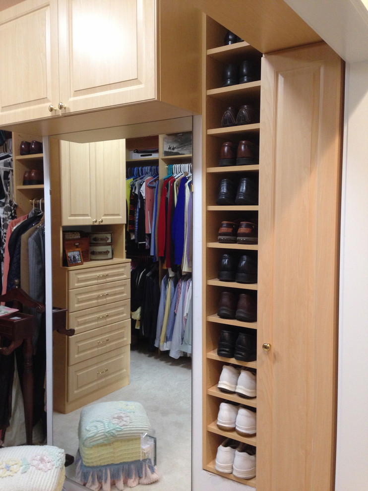 Large traditional men's dressing room in Boston with open cabinets, light wood cabinets and carpet.