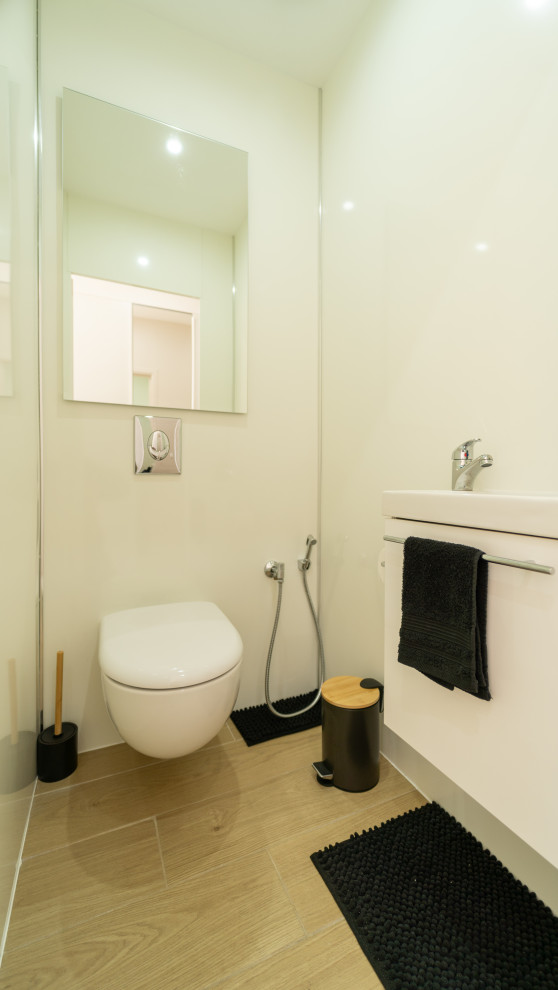 Exemple d'un WC suspendu tendance de taille moyenne avec un carrelage blanc, carrelage en métal, un lavabo suspendu, un sol beige et un plan de toilette blanc.