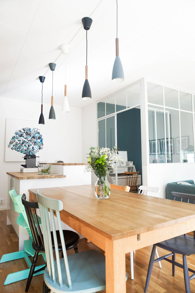 Идея дизайна: большая кухня-столовая в современном стиле с белыми стенами и светлым паркетным полом