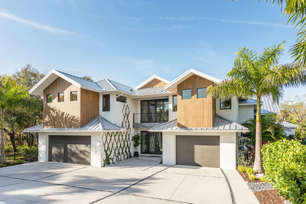 Imagen de fachada de casa multicolor y gris contemporánea con revestimientos combinados, tejado a dos aguas y tejado de metal