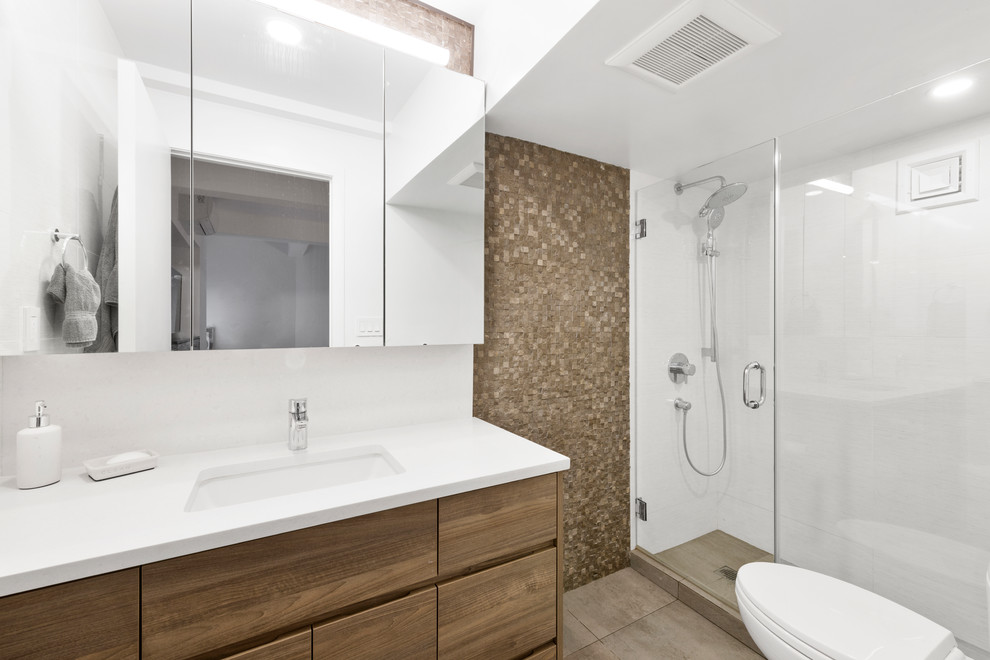 Design ideas for a small contemporary master bathroom in New York with flat-panel cabinets, brown cabinets, a double shower, a one-piece toilet, white tile, ceramic tile, beige walls, ceramic floors, a drop-in sink, quartzite benchtops, beige floor and a hinged shower door.