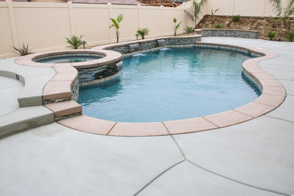 Design ideas for a mid-sized traditional backyard custom-shaped pool in Los Angeles with concrete slab.