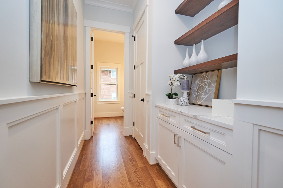 This is an example of a mid-sized transitional hallway in DC Metro with white walls, medium hardwood floors and brown floor.
