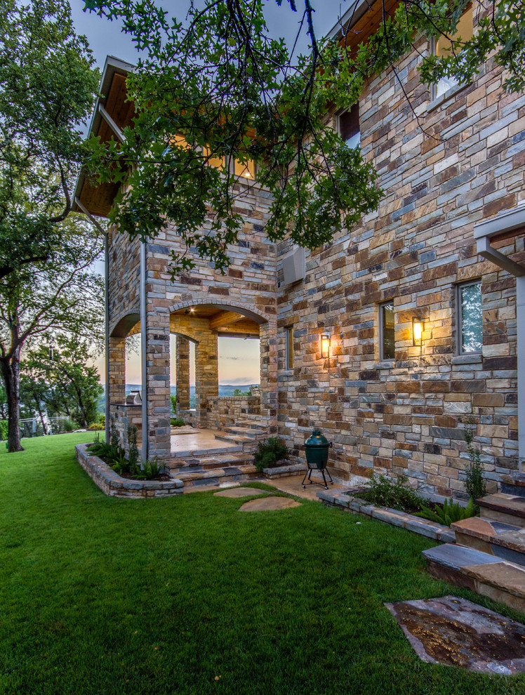 Photo of a mid-sized arts and crafts side yard patio in Austin with natural stone pavers, an outdoor kitchen and no cover.