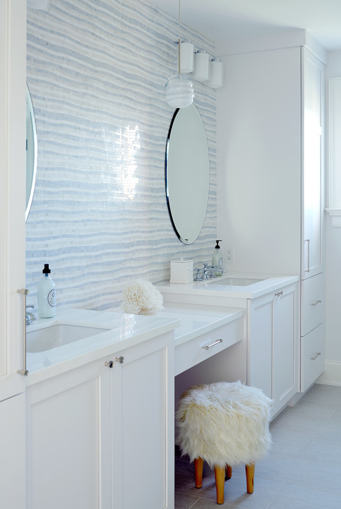 This is an example of a beach style master bathroom in New York with shaker cabinets, white cabinets, multi-coloured walls, an undermount sink, grey floor and white benchtops.