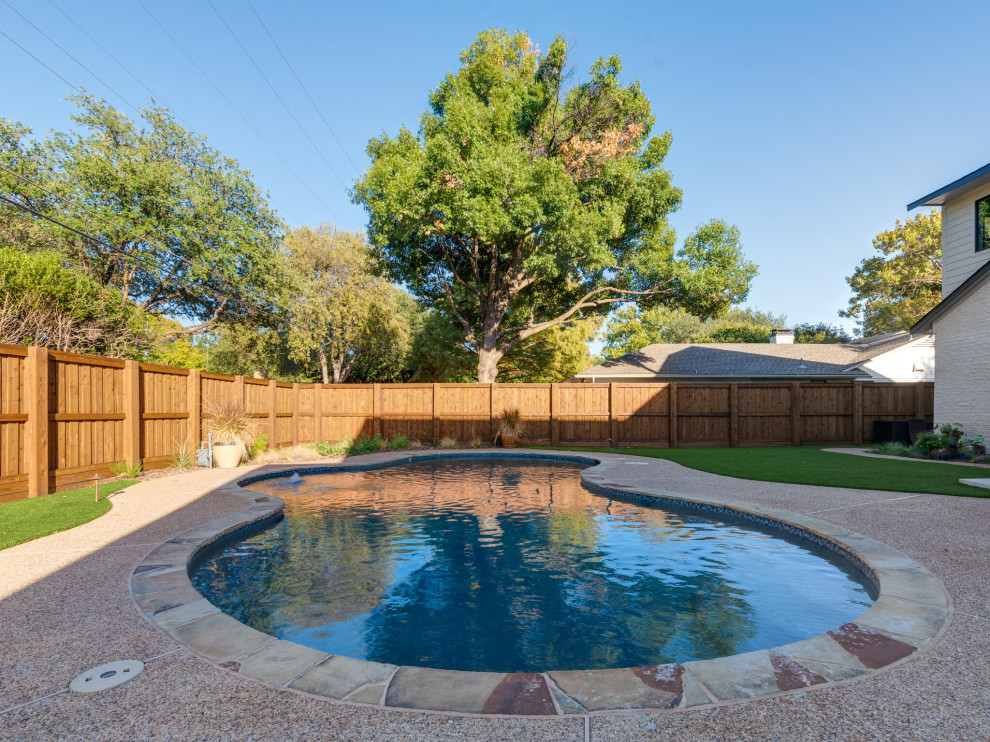 Exemple d'une piscine naturelle et arrière chic en forme de haricot avec des solutions pour vis-à-vis et une terrasse en bois.