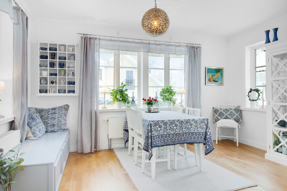 This is an example of a scandinavian separate dining room in Stockholm with grey walls, light hardwood floors and beige floor.