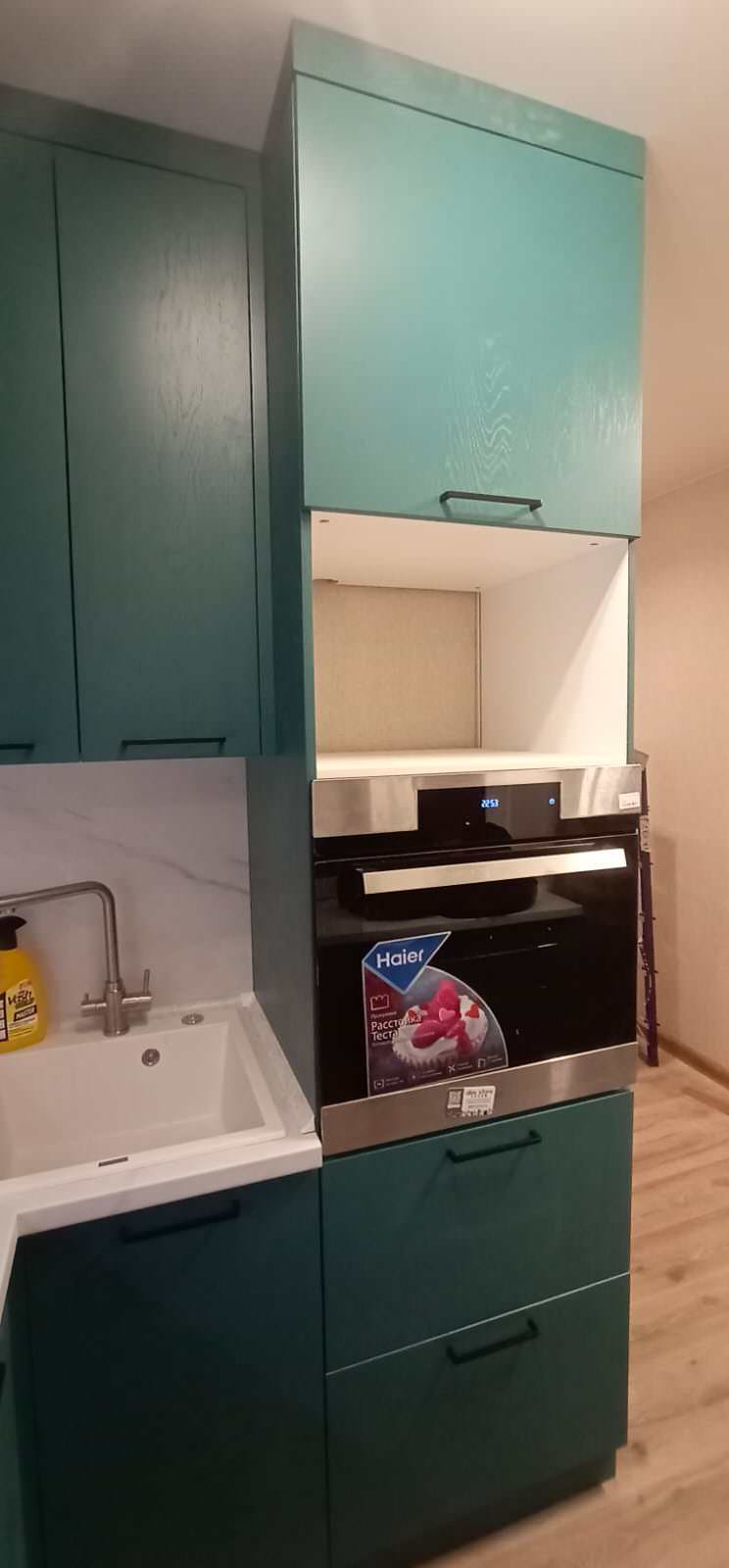 Компактная кухня в зеленом цвете с подоконником-столешницей