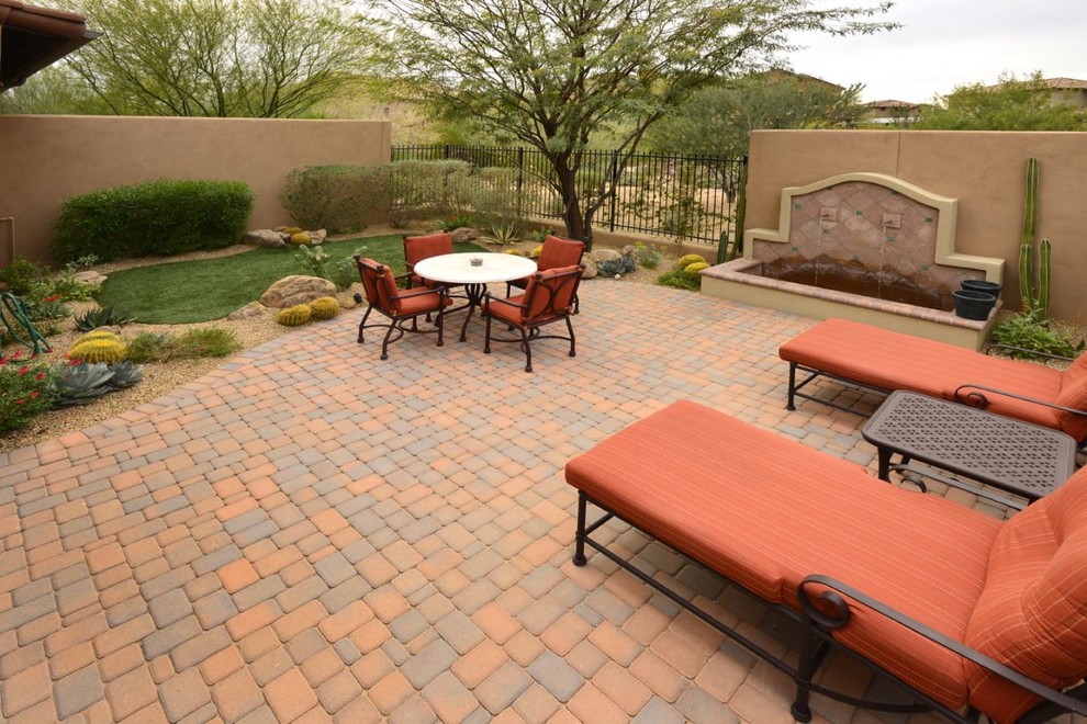 Design ideas for a large backyard patio in Phoenix with a water feature and brick pavers.