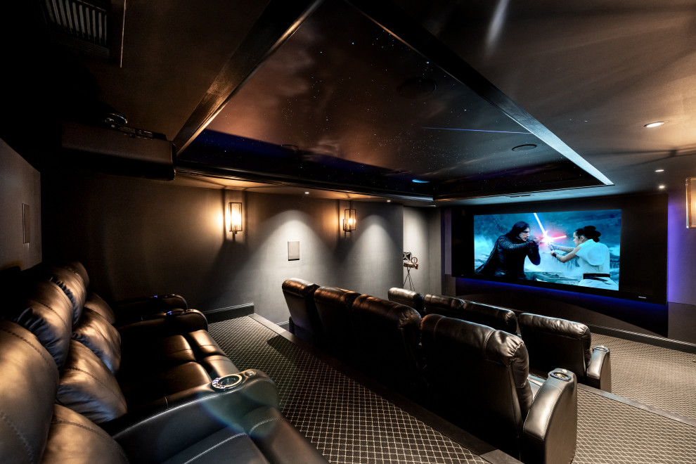 Immagine di un home theatre minimal di medie dimensioni con pareti nere, moquette, schermo di proiezione e pavimento nero