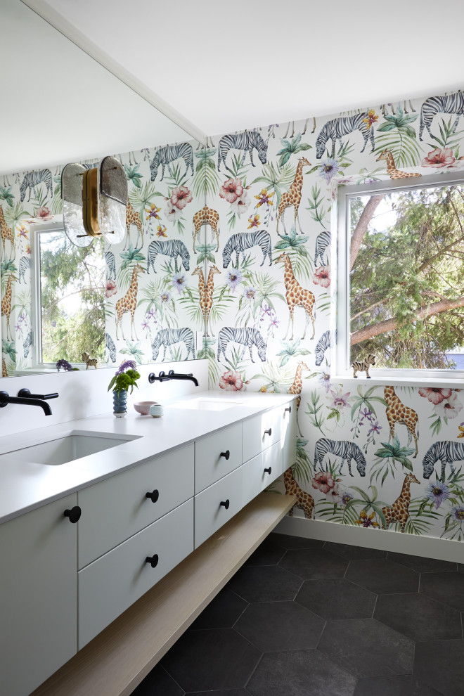 Photo of a mid-sized eclectic kids bathroom in Vancouver with flat-panel cabinets, grey cabinets, an alcove tub, an alcove shower, a one-piece toilet, multi-coloured walls, ceramic floors, an undermount sink, engineered quartz benchtops, grey floor, a shower curtain, white benchtops, a double vanity, a floating vanity and wallpaper.