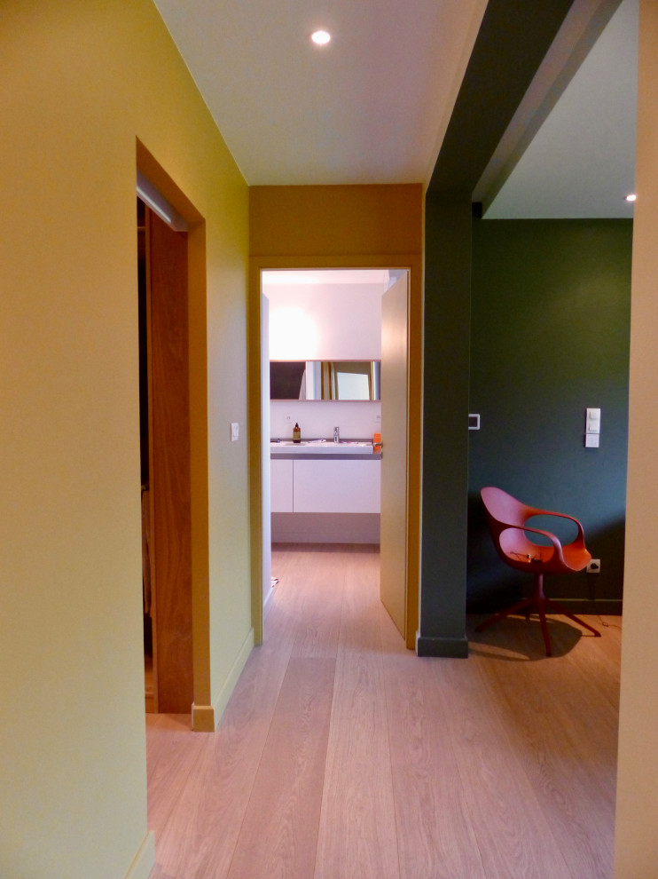 Esempio di un ingresso o corridoio minimal con pareti multicolore e parquet chiaro