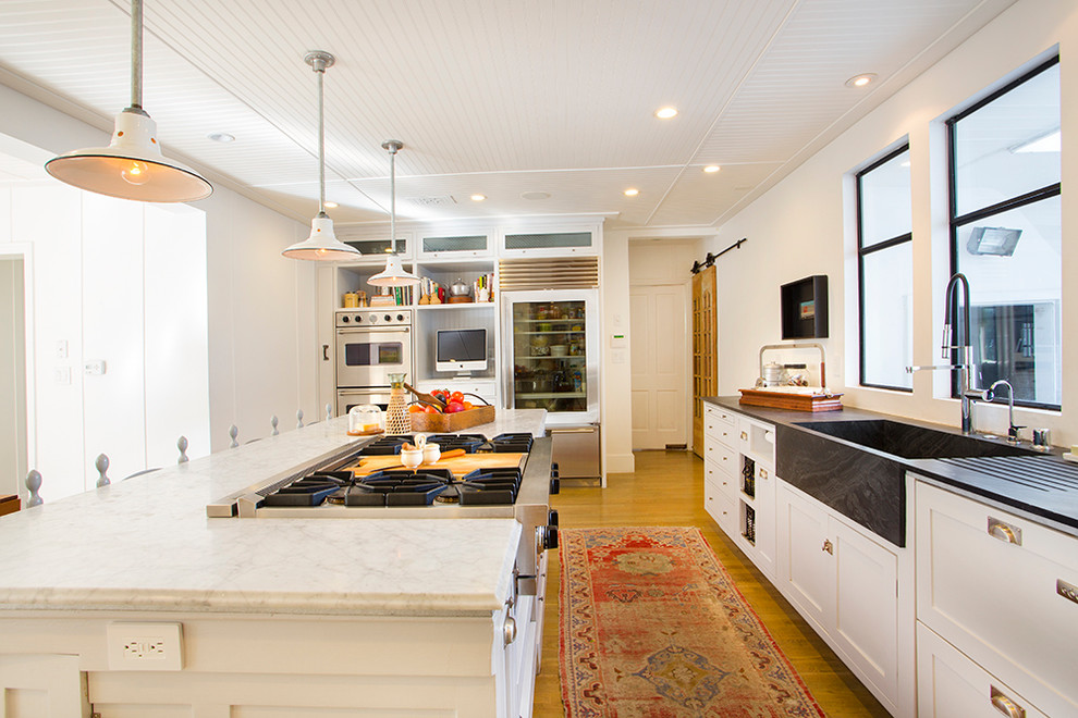 Inspiration for an eclectic kitchen in Los Angeles with an integrated sink, soapstone benchtops and white cabinets.