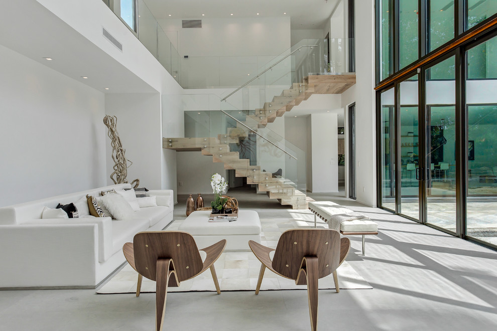 Photo of a contemporary formal open concept living room in Miami with white walls, no fireplace and grey floor.