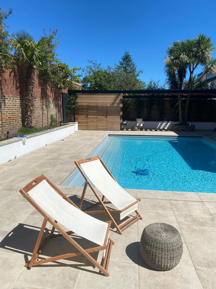 Foto de piscina minimalista de tamaño medio rectangular en patio trasero con paisajismo de piscina y adoquines de piedra natural