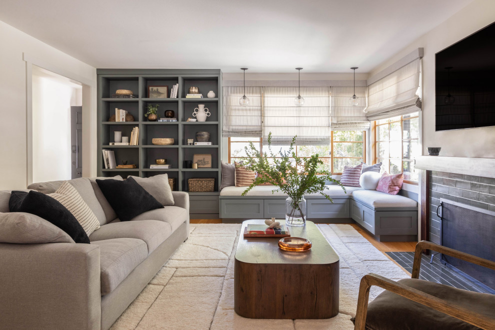 Example of a transitional enclosed medium tone wood floor and brown floor living room design in San Francisco with beige walls, a standard fireplace, a tile fireplace and a wall-mounted tv