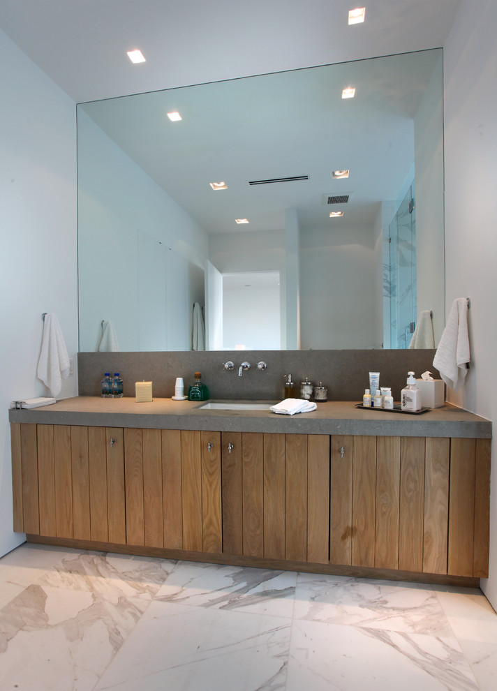 This is an example of a mid-sized modern 3/4 bathroom in Miami with medium wood cabinets, white tile, marble floors, flat-panel cabinets, stone tile, white walls, limestone benchtops, an undermount sink, grey floor and grey benchtops.