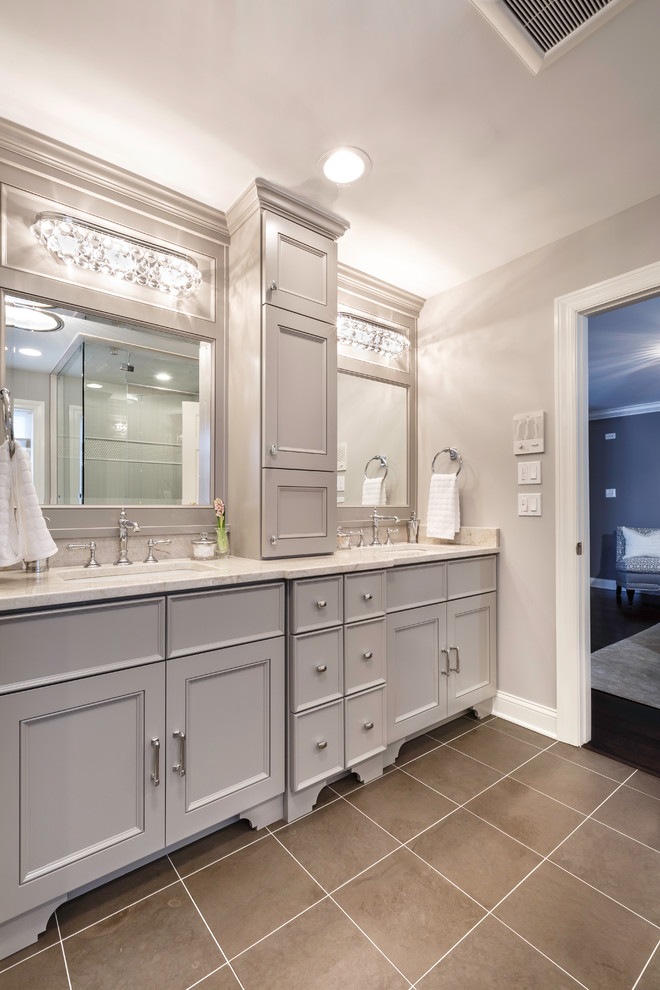 Design ideas for a mid-sized transitional master bathroom in Chicago with an undermount sink, flat-panel cabinets, grey cabinets, quartzite benchtops, a freestanding tub, a two-piece toilet, brown tile, stone tile, grey walls and limestone floors.