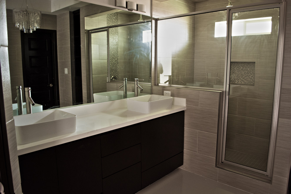 Corner shower - mid-sized transitional beige tile and porcelain tile porcelain tile corner shower idea in Austin with a vessel sink, flat-panel cabinets, dark wood cabinets and quartzite countertops