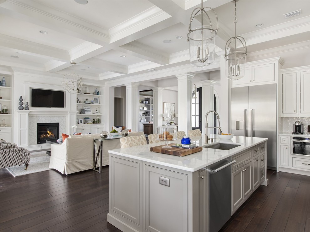 Inspiration for a large transitional l-shaped eat-in kitchen in Orlando with an undermount sink, shaker cabinets, white cabinets, marble benchtops, white splashback, ceramic splashback, stainless steel appliances, dark hardwood floors and with island.