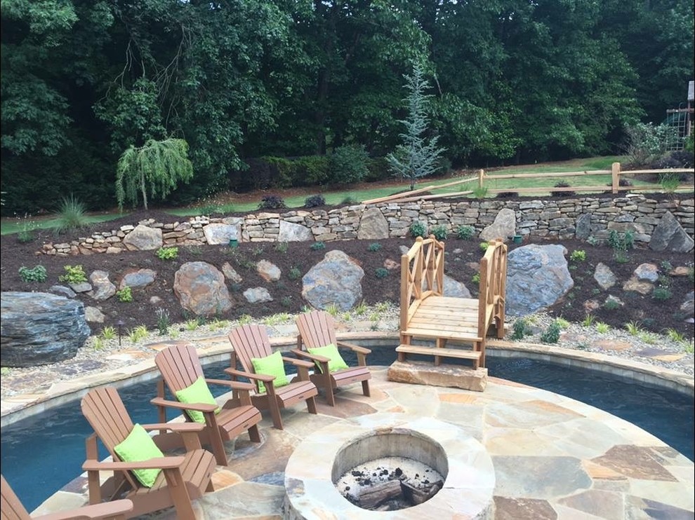 Pool - large rustic backyard custom-shaped pool idea