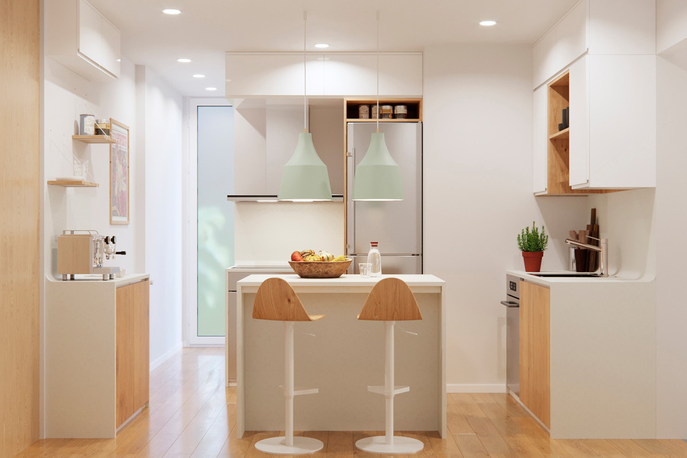 Photo of a small scandinavian u-shaped kitchen in Barcelona with an undermount sink, light wood cabinets, white splashback, stainless steel appliances, medium hardwood floors, with island, white benchtop, flat-panel cabinets and beige floor.