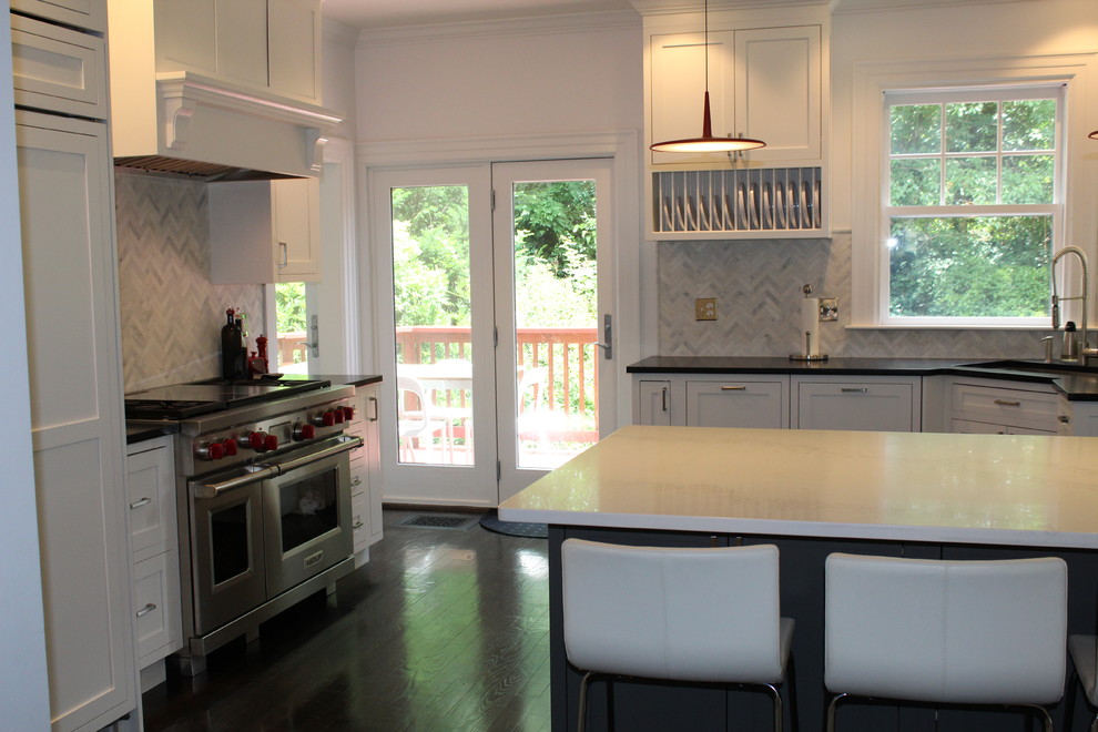 Inspiration for a large transitional dark wood floor and brown floor enclosed kitchen remodel in Boston with a single-bowl sink, shaker cabinets, white cabinets, soapstone countertops, gray backsplash, marble backsplash, stainless steel appliances and an island