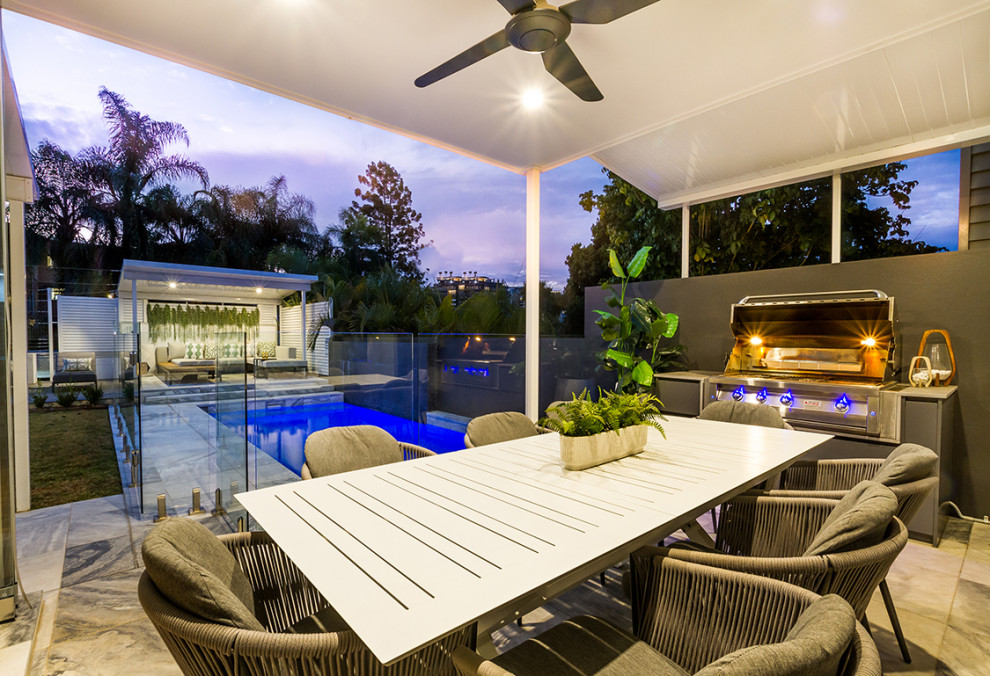 Inspiration for a large contemporary backyard deck in Brisbane with a water feature and a roof extension.