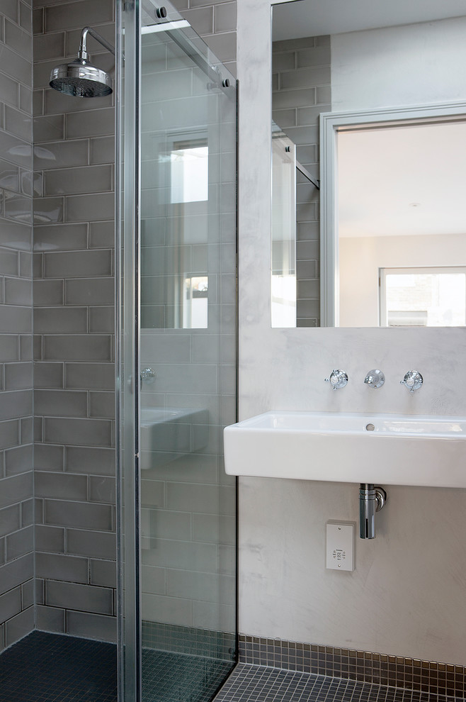 Design ideas for a mid-sized contemporary master bathroom in London with a drop-in tub, an open shower, a wall-mount toilet, gray tile, ceramic tile, grey walls, cement tiles, a wall-mount sink, grey floor and a sliding shower screen.