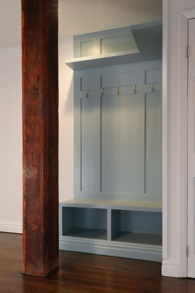 Small industrial mudroom in New York with green walls, dark hardwood floors and panelled walls.