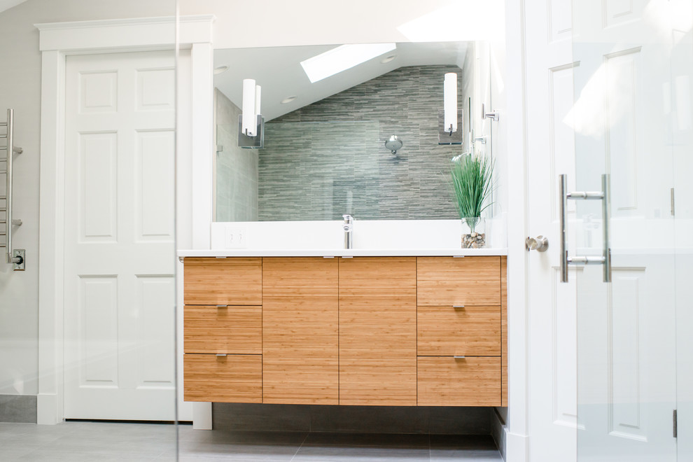 This is an example of a large transitional master bathroom in Portland Maine with flat-panel cabinets, light wood cabinets, a corner tub, an alcove shower, a two-piece toilet, white tile, white walls, ceramic floors and an undermount sink.