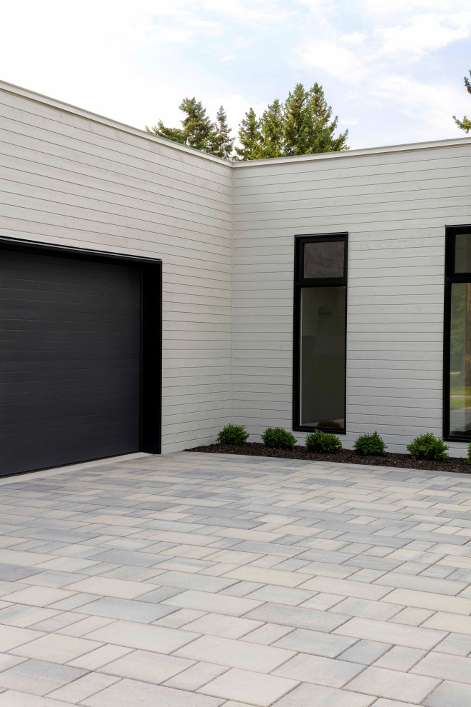 Modern front yard driveway in Montreal with concrete pavers.