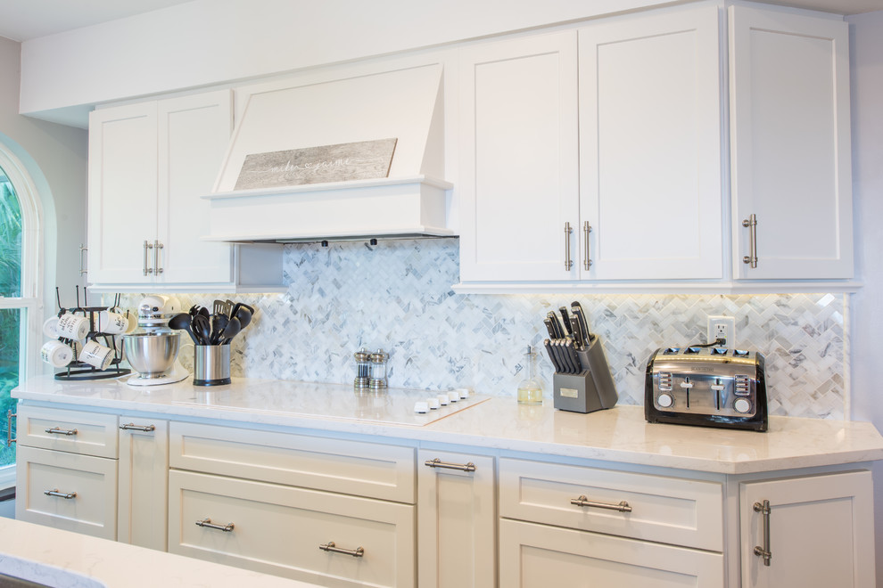 Eat-in kitchen - large transitional u-shaped porcelain tile and brown floor eat-in kitchen idea with an undermount sink, shaker cabinets, white cabinets, quartz countertops, white backsplash, marble backsplash, stainless steel appliances and two islands