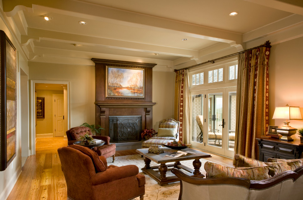Design ideas for a traditional open concept family room in Charlotte with beige walls, light hardwood floors, a standard fireplace and a wood fireplace surround.