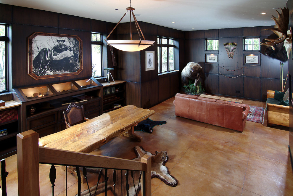 This is an example of a large traditional enclosed family room in Grand Rapids with brown walls and concrete floors.