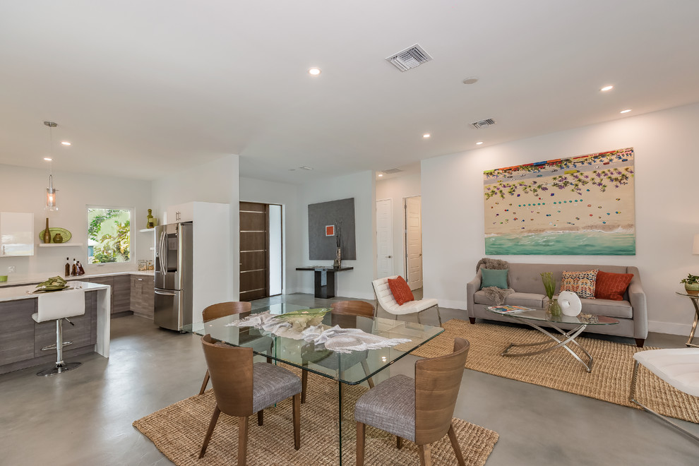 Large modern open concept living room in Tampa with white walls, concrete floors and grey floor.