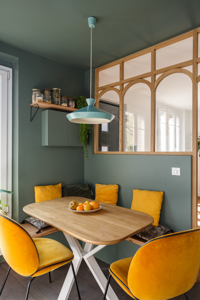 This is an example of a mid-sized scandinavian l-shaped separate kitchen in Paris with an undermount sink, flat-panel cabinets, white cabinets, granite benchtops, green splashback, ceramic splashback, panelled appliances, ceramic floors, no island, grey floor and black benchtop.