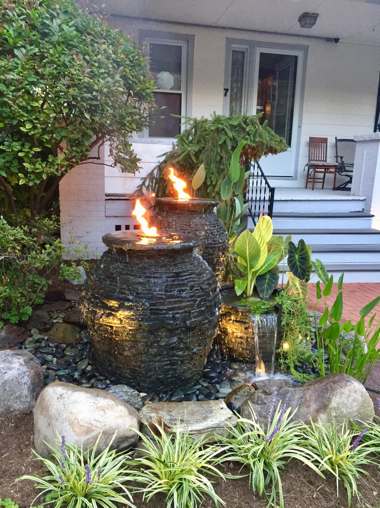 Small traditional front yard partial sun formal garden in New York with a fire feature and brick pavers for summer.