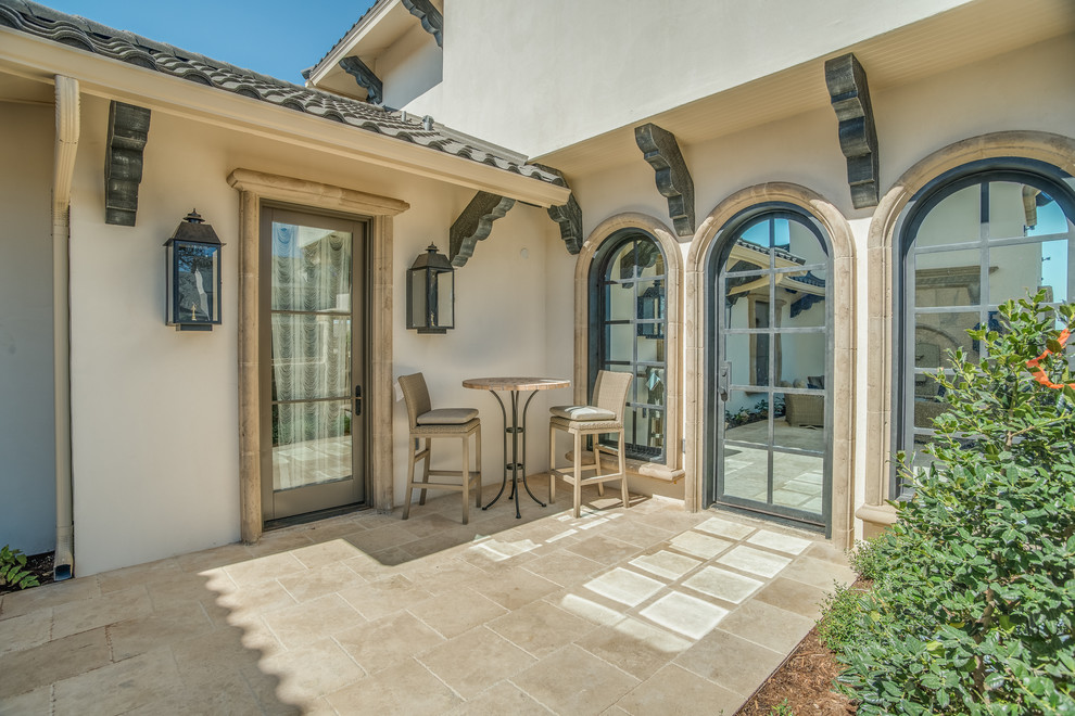This is an example of a mid-sized traditional patio in Austin with tile and no cover.