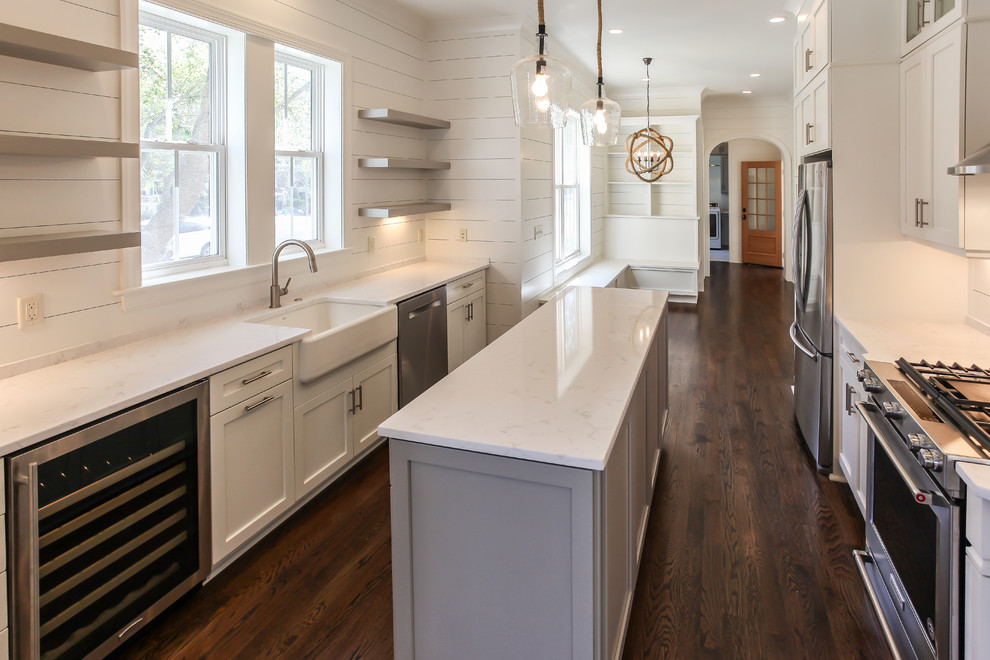 Inspiration for a beach style galley eat-in kitchen in Charleston with a farmhouse sink, open cabinets, white cabinets, quartzite benchtops, stainless steel appliances, dark hardwood floors and with island.