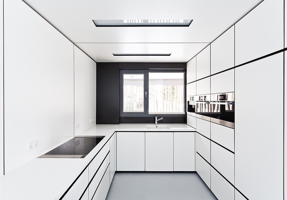 Design ideas for a mid-sized modern u-shaped kitchen in Dresden with an integrated sink, flat-panel cabinets, white cabinets, black splashback, stainless steel appliances and no island.