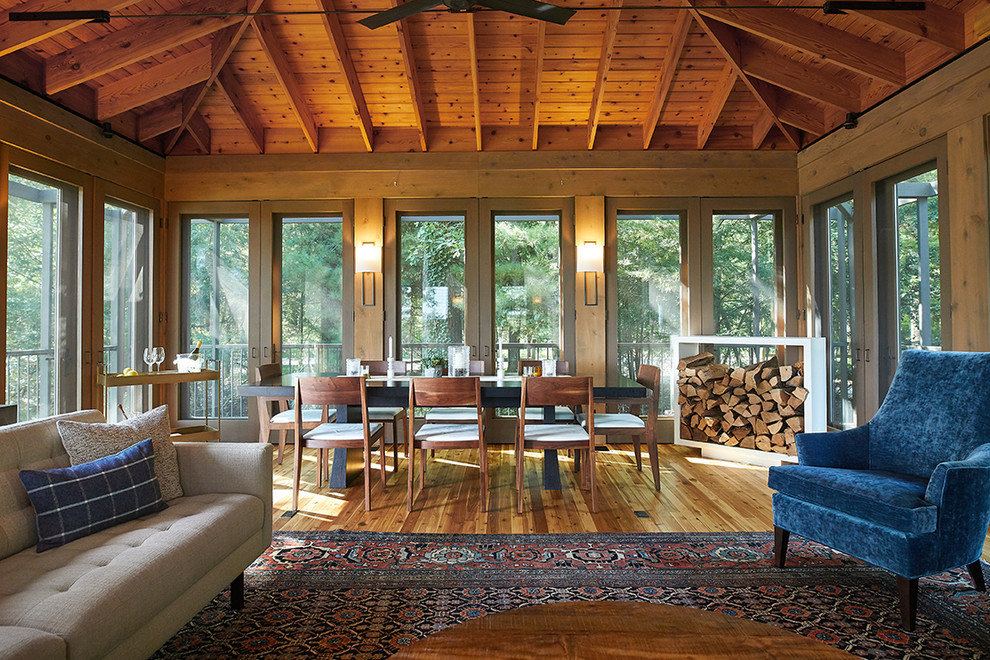 Inspiration for a country sunroom in Grand Rapids with medium hardwood floors, brown floor, a standard ceiling, a standard fireplace and a metal fireplace surround.