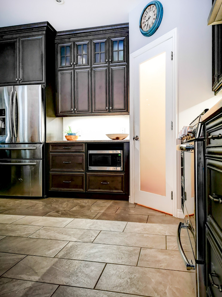 Inspiration for a mid-sized rustic l-shaped medium tone wood floor and brown floor eat-in kitchen remodel with a double-bowl sink, recessed-panel cabinets, dark wood cabinets, granite countertops, stainless steel appliances, an island and gray countertops