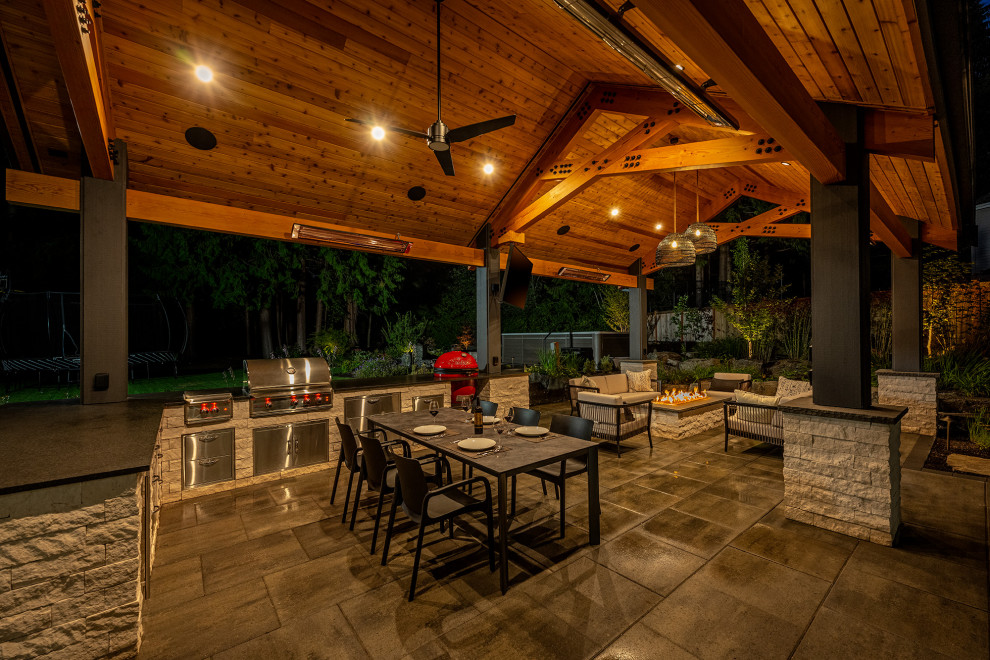 Photo of a large contemporary backyard garden in Seattle with a fire feature and natural stone pavers.