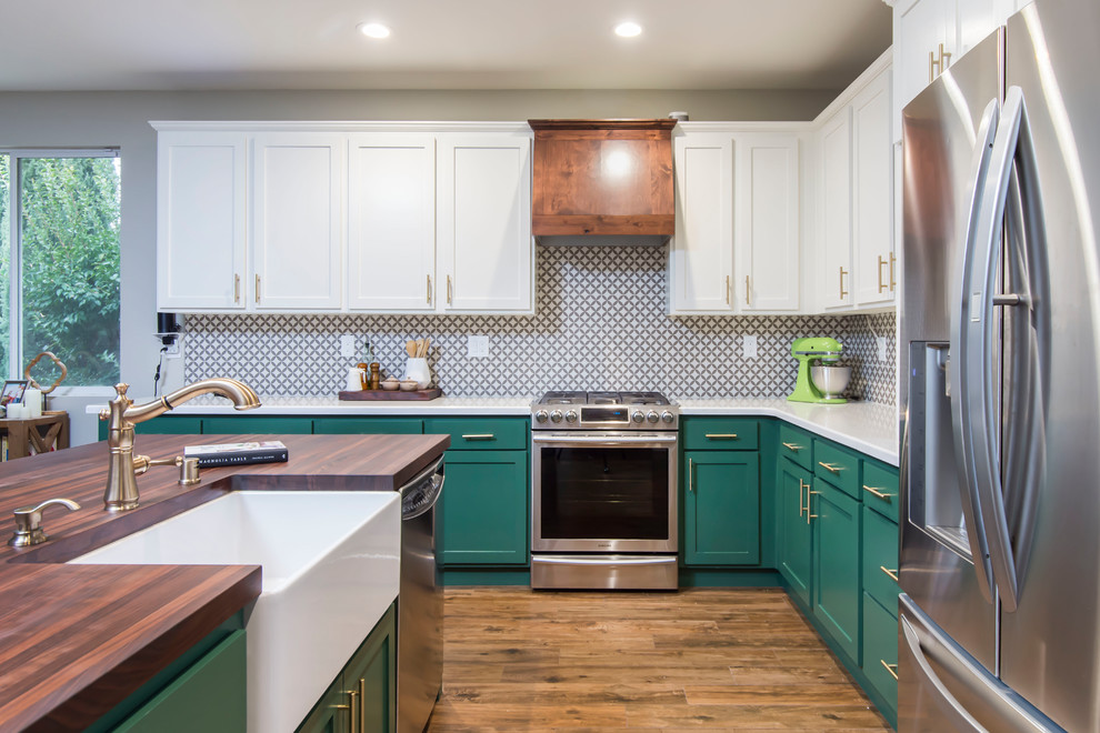Inspiration for a large transitional l-shaped eat-in kitchen in Los Angeles with a farmhouse sink, shaker cabinets, green cabinets, multi-coloured splashback, porcelain splashback, stainless steel appliances, with island, brown floor, wood benchtops, porcelain floors and brown benchtop.