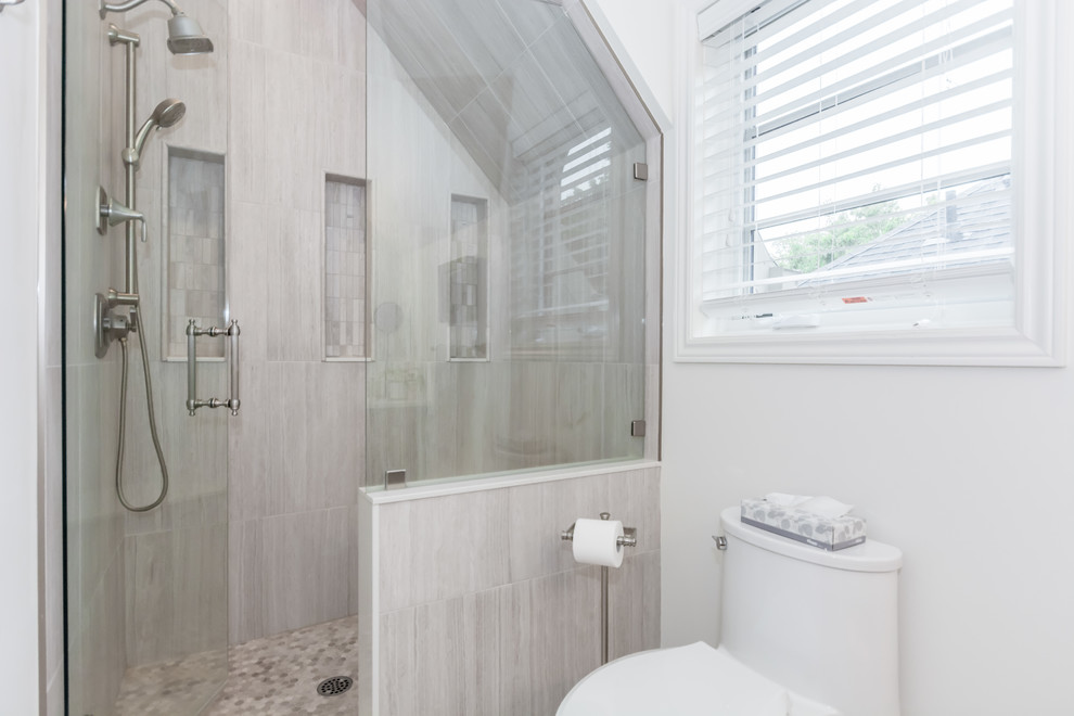 Inspiration for a mid-sized transitional kids bathroom in Toronto with an alcove shower, a one-piece toilet, gray tile, porcelain tile, white walls, mosaic tile floors, grey floor and a hinged shower door.