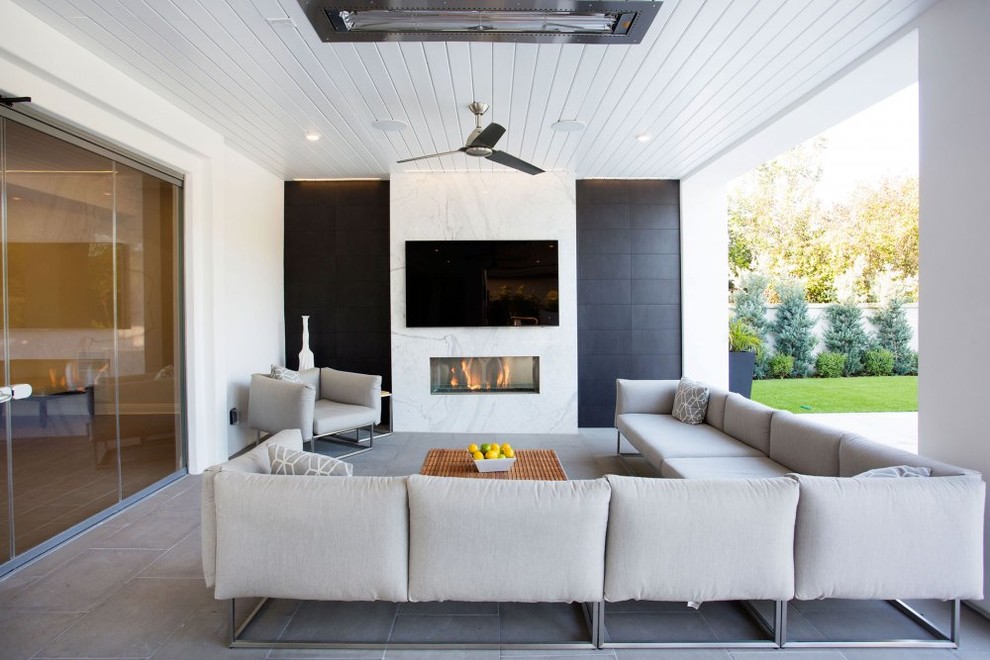 Inspiration for a contemporary patio in Los Angeles with a roof extension and with fireplace.