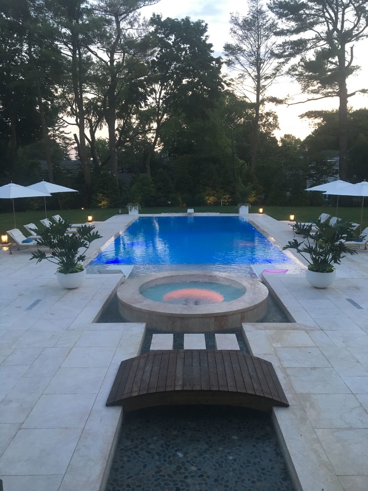 Example of a large backyard stone and rectangular lap hot tub design in New York